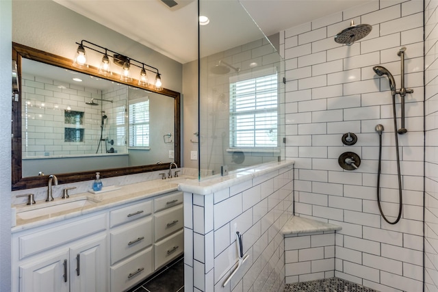 bathroom with vanity, plenty of natural light, and tiled shower