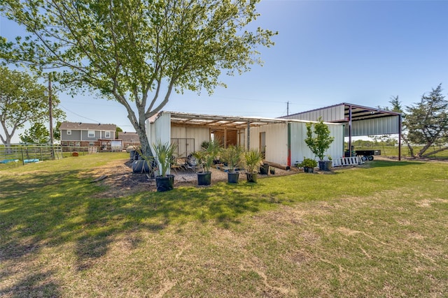 rear view of house featuring a yard and an outdoor structure