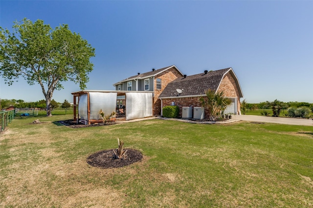 back of property with cooling unit, a garage, and a lawn