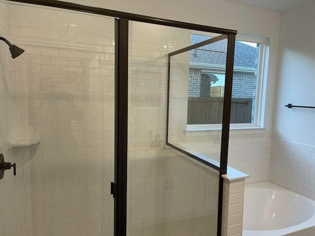 bathroom featuring shower with separate bathtub