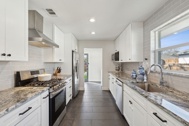 kitchen featuring stainless steel appliances, sink, white cabinets, and wall chimney exhaust hood