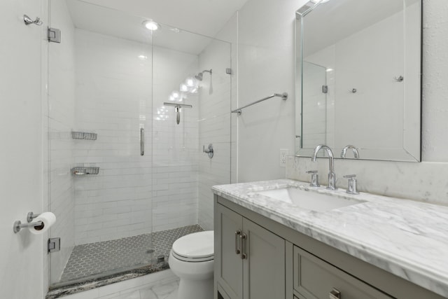 bathroom with walk in shower, vanity, and toilet