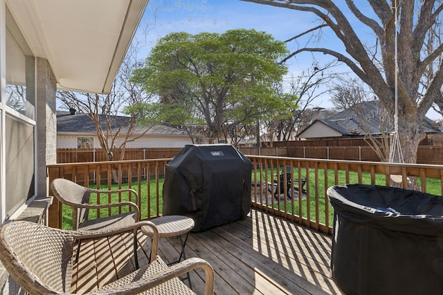 wooden deck with area for grilling and a lawn