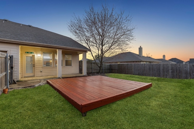 yard at dusk featuring a wooden deck