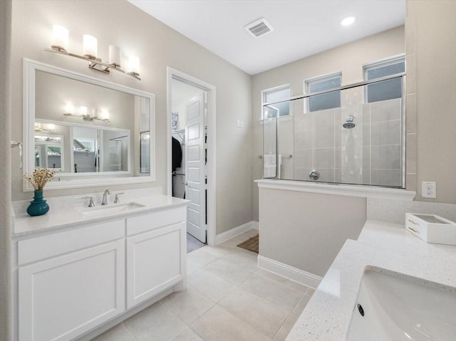 bathroom with vanity, tile patterned flooring, and tiled shower