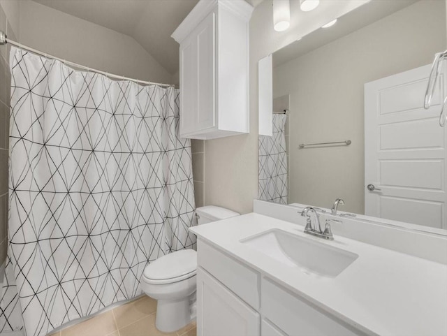 bathroom with vanity, tile patterned flooring, lofted ceiling, and toilet