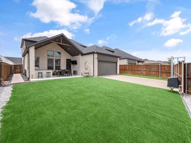 view of front of home featuring a garage, a front yard, and a patio area