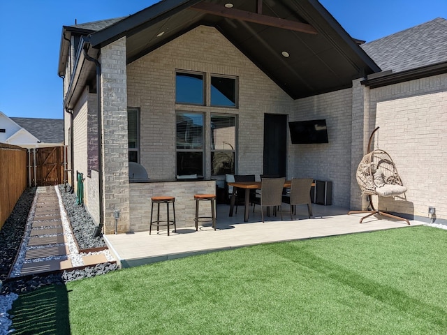 back of property featuring a patio, a lawn, and a bar