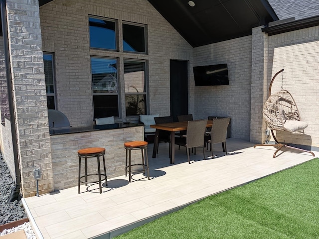 view of patio / terrace with exterior kitchen and a bar