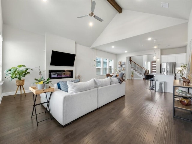 living room with dark wood-type flooring, ceiling fan, high vaulted ceiling, and beamed ceiling