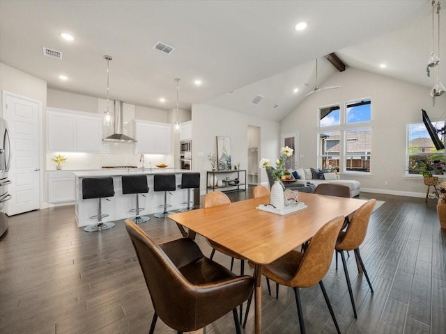 dining room featuring sink, ceiling fan, high vaulted ceiling, dark hardwood / wood-style flooring, and beamed ceiling