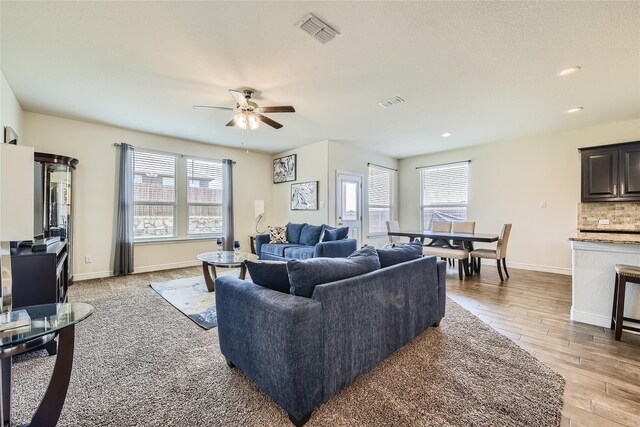 living room with ceiling fan and light wood-type flooring