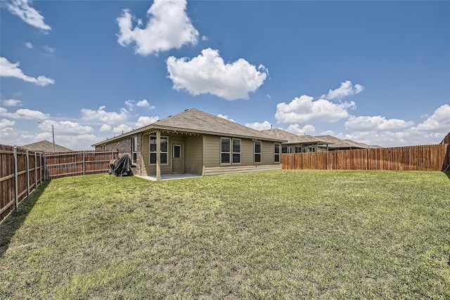 back of property with a yard and a patio