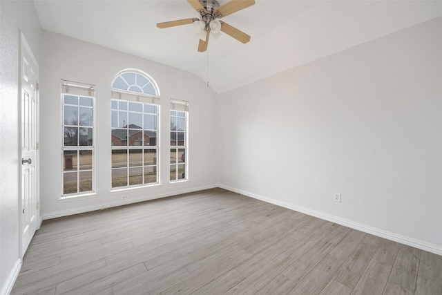 empty room with vaulted ceiling, ceiling fan, and light wood-type flooring