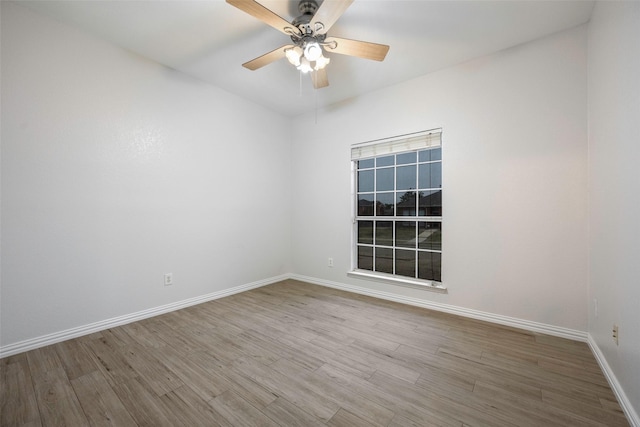 empty room with ceiling fan and light hardwood / wood-style flooring