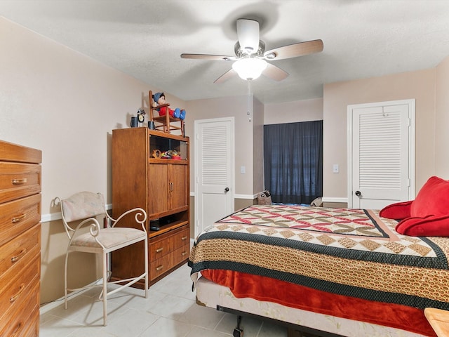 bedroom with light tile patterned floors, a textured ceiling, and ceiling fan