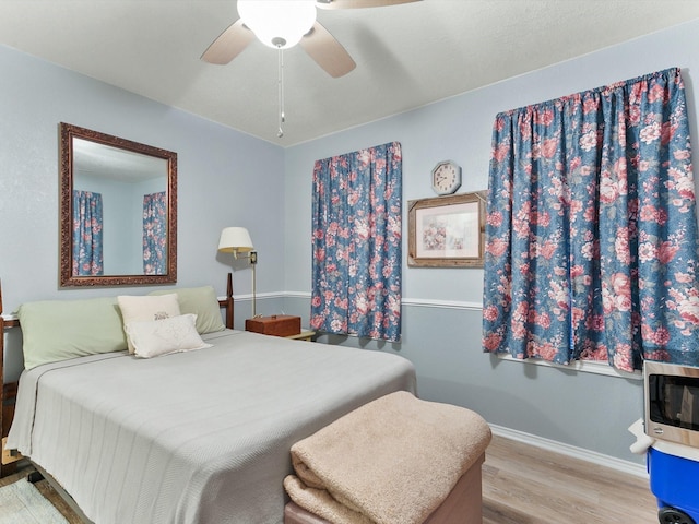 bedroom with light hardwood / wood-style flooring and ceiling fan