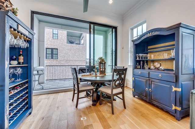 dining area with light hardwood / wood-style flooring and ornamental molding