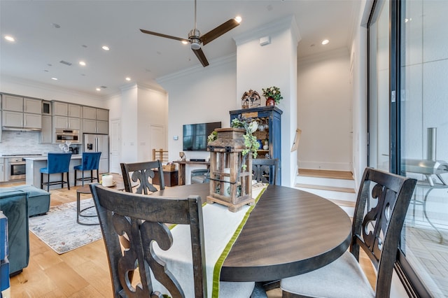 dining room featuring ornamental molding, light hardwood / wood-style floors, and ceiling fan