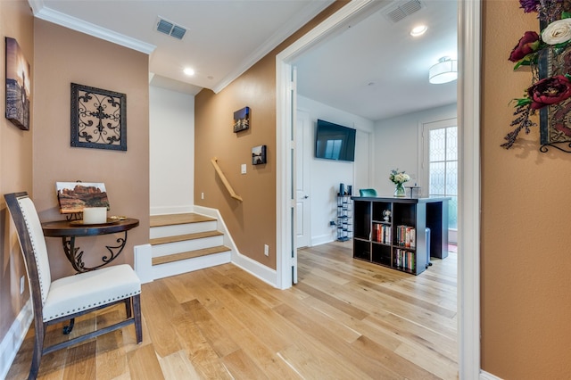 hall featuring crown molding and light hardwood / wood-style floors