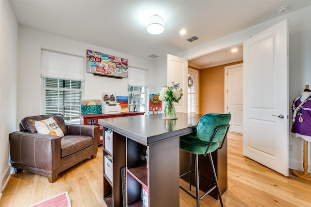 kitchen with a breakfast bar area, light hardwood / wood-style floors, and white cabinets