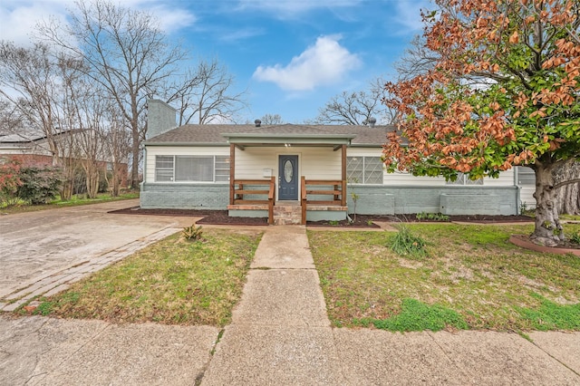 bungalow-style home featuring a front yard and covered porch