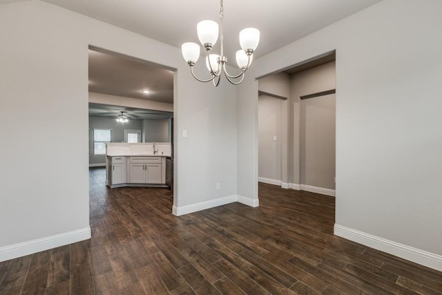 unfurnished dining area featuring dark hardwood / wood-style floors and ceiling fan with notable chandelier