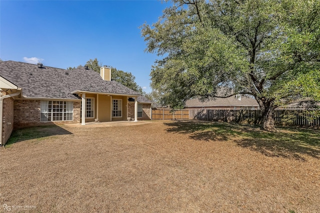 rear view of property with a lawn and a patio area