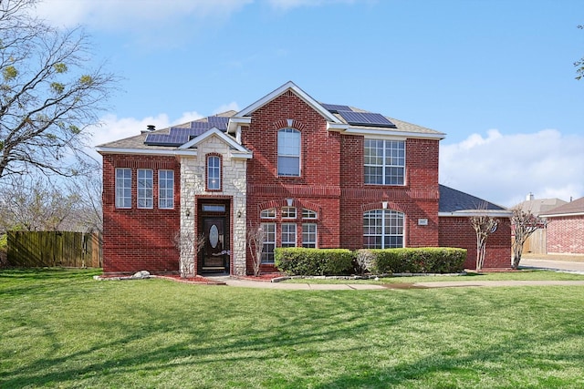 view of front of home with a front lawn and solar panels