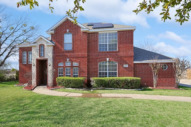 view of front of property featuring a front yard and solar panels