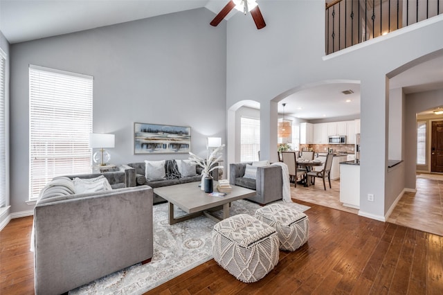 living room featuring hardwood / wood-style flooring, high vaulted ceiling, and ceiling fan