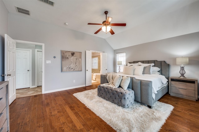 bedroom featuring lofted ceiling, ensuite bath, dark hardwood / wood-style floors, and ceiling fan