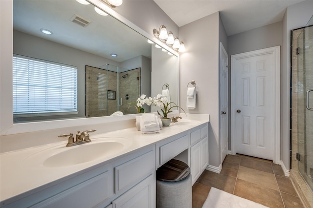 bathroom featuring vanity, a shower with shower door, and tile patterned flooring