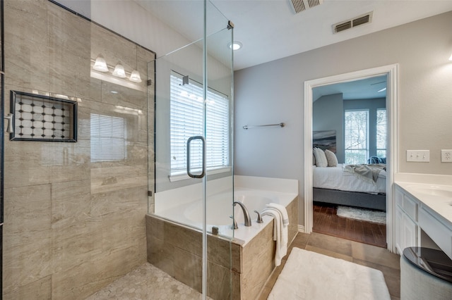 bathroom with shower with separate bathtub, a wealth of natural light, tile patterned floors, and vanity