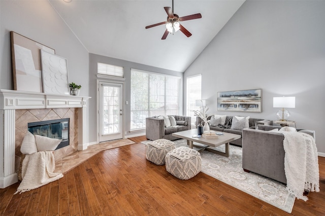 living room with a fireplace, wood-type flooring, high vaulted ceiling, and ceiling fan