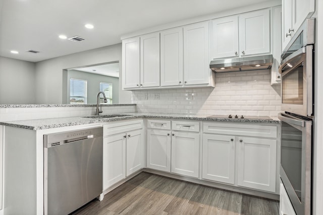 kitchen featuring light stone countertops, white cabinetry, appliances with stainless steel finishes, and sink