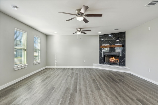 unfurnished living room featuring ceiling fan, a fireplace, and hardwood / wood-style floors