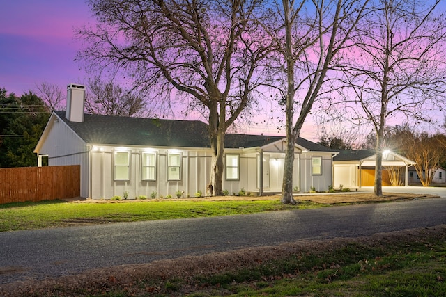 ranch-style home with a garage and a yard