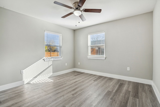 empty room featuring hardwood / wood-style flooring, ceiling fan, and a wealth of natural light