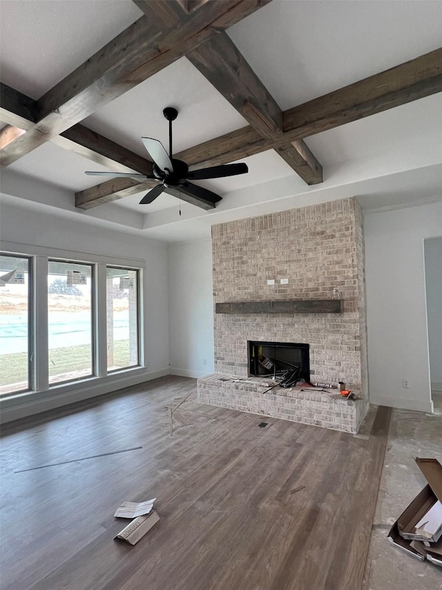 unfurnished living room featuring coffered ceiling, a fireplace, wood-type flooring, and beamed ceiling