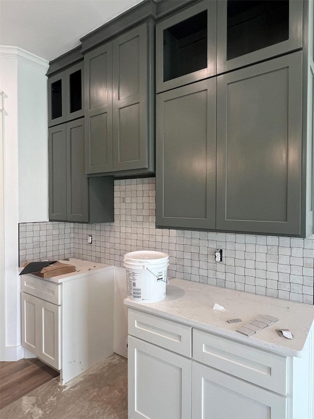 interior space with tasteful backsplash, dark hardwood / wood-style floors, light stone countertops, and white cabinets