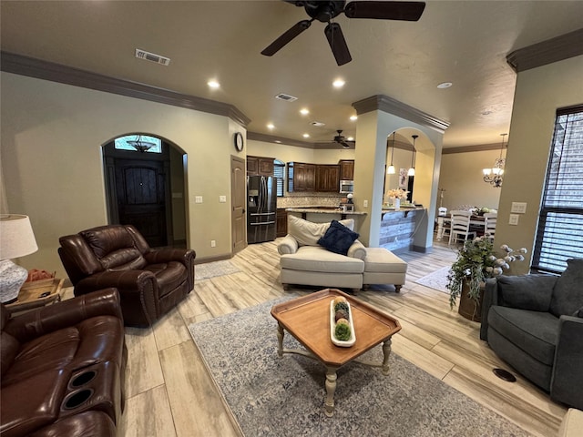 living room with crown molding, ceiling fan with notable chandelier, and light hardwood / wood-style floors