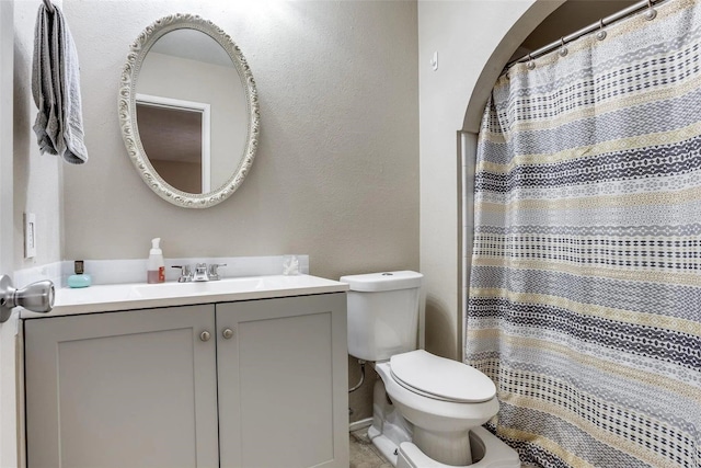 bathroom featuring a shower with curtain, vanity, and toilet