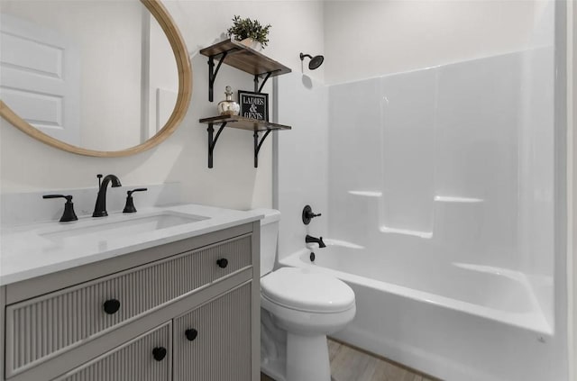 full bathroom with hardwood / wood-style flooring, shower / tub combination, vanity, and toilet