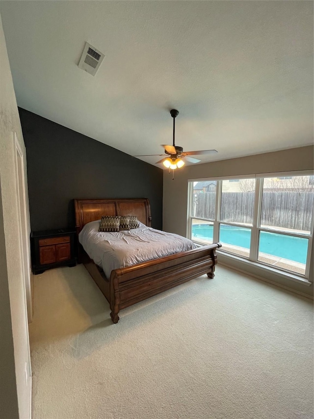 carpeted bedroom with vaulted ceiling and ceiling fan