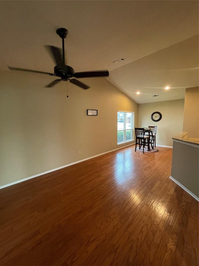 empty room featuring ceiling fan, dark hardwood / wood-style floors, and vaulted ceiling