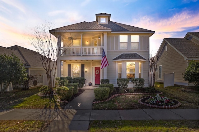 view of front of property featuring a balcony and covered porch