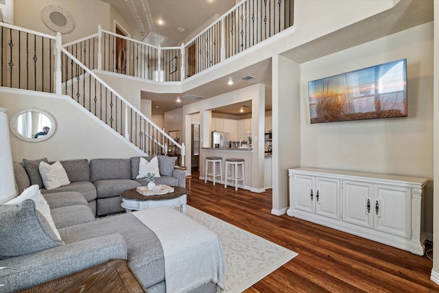 living room featuring a high ceiling and dark wood-type flooring