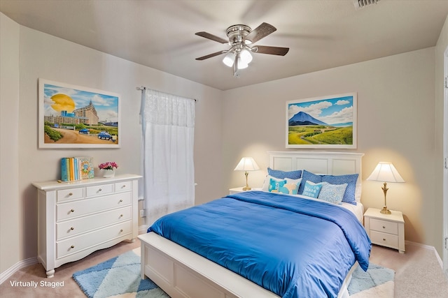 bedroom with ceiling fan and light carpet