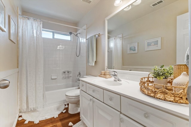 full bathroom with shower / tub combo with curtain, hardwood / wood-style floors, vanity, and toilet